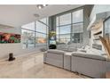 Modern living room featuring floor-to-ceiling windows, multiple TVs, and a gray sectional sofa at 4515 Dean Martin Dr # 200, Las Vegas, NV 89103
