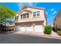 Inviting townhome featuring a three-car garage and neutral stucco exterior, perfect for modern living at 4608 Snake Eyes St # 102, Las Vegas, NV 89122