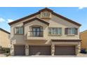Beautiful three-story home featuring three-car garage and classic desert architecture with a balcony at 4650 Ridgeley Ave # 103, North Las Vegas, NV 89084
