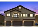 Stunning exterior of a three-story home showcases a three-car garage and classic desert architecture at twilight at 4650 Ridgeley Ave # 103, North Las Vegas, NV 89084
