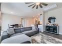 Inviting living space with a gray sofa, modern ceiling fan, and an open layout leading to the kitchen at 4720 Flower Moon Ave # 101, North Las Vegas, NV 89084