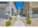 Exterior walkway between townhome buildings with desert landscaping at 4720 Flower Moon Ave # 101, North Las Vegas, NV 89084