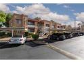 Wide exterior view of tan condos with parking underneath and desert landscaping under a cloudy sky at 5114 S Jones Blvd # 202, Las Vegas, NV 89118