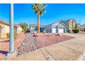 Single-story home boasting a low maintenance yard, a large palm tree and a convenient two-car garage at 52 Vallejo Verde St, Henderson, NV 89012