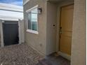 Front entrance area features a gravel groundcover, stylish wall-mounted light fixture, and neutral exterior paint at 6830 Truffle Gray St, Las Vegas, NV 89148