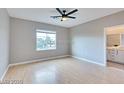 Spacious bedroom featuring wood floors, a ceiling fan, and a window at 7047 Sombra Way, Las Vegas, NV 89113