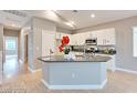 This kitchen features an island with gray countertops and white cabinets at 7047 Sombra Way, Las Vegas, NV 89113