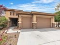 Well-maintained home featuring a two-car garage, desert landscaping, and a quaint covered entryway at 7505 Java Sparrow St, North Las Vegas, NV 89084