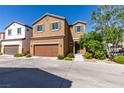 Two-story tan home featuring a two-car garage, neutral landscaping and a tile roof at 7609 Aubusson Ct, Las Vegas, NV 89149
