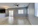Open concept living room with tile floors, neutral gray paint, a ceiling fan and view of the kitchen at 7609 Aubusson Ct, Las Vegas, NV 89149