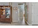 Inviting hallway featuring wood-look flooring, neutral walls, and a decorative display cabinet at 7669 Fieldfare Dr, North Las Vegas, NV 89084