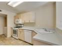 Practical kitchen with white appliances, neutral countertops, and tile flooring at 7732 Almeria Ave, Las Vegas, NV 89128