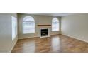 Open living room with fireplace, wood flooring, and plenty of natural light at 7732 Almeria Ave, Las Vegas, NV 89128