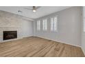 Bright living room with stylish wood floors, a stone fireplace, and multiple windows at 8409 Insignia Ave # 102, Las Vegas, NV 89178