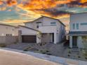 Contemporary two-story home with desert landscaping and a two-car garage during sunset at 10204 Kern Peak St, Las Vegas, NV 89166