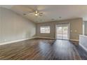 Spacious living room with ceiling fan, wood-look floors and sliding glass doors to backyard at 10311 Slope Ridge St, Las Vegas, NV 89131