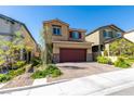 Charming two-story home with desert landscaping, a red garage door, and a brick-paved driveway at 10939 Cheshire Woods Ave, Las Vegas, NV 89166