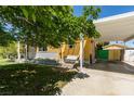 Charming single-story house with a covered carport, a bench swing on the porch, and mature trees at 1127 Melville Dr, Las Vegas, NV 89102