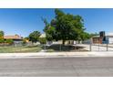 Cozy single-story house surrounded by a chain-link fence, mature trees, and a well-kept front yard at 1127 Melville Dr, Las Vegas, NV 89102
