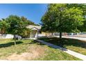 A quaint single-story residence features a lovely lawn, mature trees, and a walkway leading to the entrance at 1127 Melville Dr, Las Vegas, NV 89102