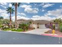 Spacious driveway of single-story home with desert landscaping and an attached three-car garage at 11527 Morning Grove Dr, Las Vegas, NV 89135