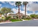 Well-maintained front yard featuring a lush lawn, mature trees, and manicured shrubs framing this beautiful home at 11527 Morning Grove Dr, Las Vegas, NV 89135