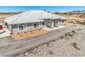 Spacious single story home boasts a xeriscaped yard and a white tile roof, offering both style and low-maintenance living at 1410 Tiptop Trl, Pahrump, NV 89048