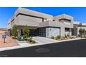 Contemporary home featuring a three-car garage, desert landscaping, and minimalist architectural elements at 1548 Pleasant Bay Ct, Henderson, NV 89011