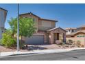 Charming two-story home featuring a stone facade, two car garage, and low maintenance desert landscaping at 253 Kindly Way, Henderson, NV 89011
