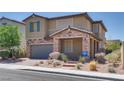 Charming two-story home featuring a stone facade, two car garage, and low maintenance desert landscaping at 253 Kindly Way, Henderson, NV 89011