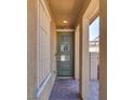 Inviting front porch featuring tiled flooring, a secure ring doorbell, and a green colored front door at 253 Kindly Way, Henderson, NV 89011