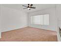 Inviting bedroom featuring soft carpet, a ceiling fan, and a large window for ample natural light at 2573 Grandville Ave, Henderson, NV 89052