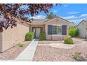 Close-up of the home's front yard, showcasing the desert landscaping, mature trees, and covered entrance at 2573 Grandville Ave, Henderson, NV 89052