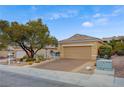 Charming single-story home showcasing desert landscaping, a spacious driveway, and mature trees at 2820 Goldcreek St, Henderson, NV 89052