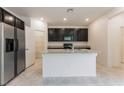 Bright kitchen showcases an island, stainless steel refrigerator, and ample cabinet space for storage at 2824 Mozia Ct, Henderson, NV 89044