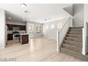 Bright, open-concept living space with wood-look floors, stairs, and a kitchen with stainless steel appliances at 3526 Harbor Tides St, Las Vegas, NV 89147
