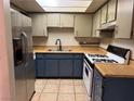 Kitchen with stainless steel refrigerator, gas range, tile flooring and plenty of cabinet storage at 4338 Caliente St # 8, Las Vegas, NV 89119