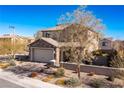 Two-story home with a tile roof, stone accents and low maintenance desert landscaping with an attached two-car garage at 436 Trevinca St, Las Vegas, NV 89138