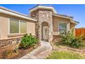 Inviting front entrance with stone accents, manicured shrubs, and a charming walkway at 474 Adelle Ave, Overton, NV 89040
