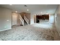 Open-concept living room with modern carpeting, staircase, and recessed lighting adjacent to the kitchen at 483 Fairview Hills St, Las Vegas, NV 89138