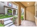Covered entryway featuring brick flooring with inviting views of landscaped community at 49 Alamere Falls Dr, Las Vegas, NV 89138
