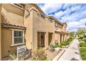 Inviting front exterior of townhome featuring covered entry and verdant landscaping at 49 Alamere Falls Dr, Las Vegas, NV 89138