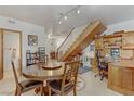 Open-concept dining room, featuring a large round table, built-in desk, and a staircase at 4998 Schumann Dr, Las Vegas, NV 89146