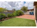 Backyard features artifical turf, gravel beds and a block wall for privacy at 5001 Volcanic Rock Ln, Las Vegas, NV 89122