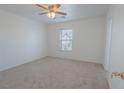 Clean, carpeted bedroom with ceiling fan and view of the outdoors from the window at 5001 Volcanic Rock Ln, Las Vegas, NV 89122