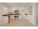 Bright kitchen featuring white cabinets, stainless steel appliances, and tile flooring at 5001 Volcanic Rock Ln, Las Vegas, NV 89122