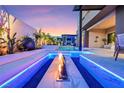 Luxurious backyard with a modern fire pit, ambient lighting, and comfortable seating area at 10718 Desert Heights Ave, Las Vegas, NV 89135