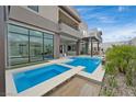 Modern home with a sleek pool and spa surrounded by lush landscaping, offering a private retreat at 10718 Desert Heights Ave, Las Vegas, NV 89135