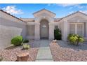 Inviting front entrance with stone walkway, desert landscaping, and arched porch at 11032 Mission Lakes Ave, Las Vegas, NV 89134