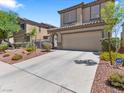 Inviting two-story home features desert landscaping and a wide driveway leading to a two-car garage at 1124 Aspen Cliff Dr, Henderson, NV 89011